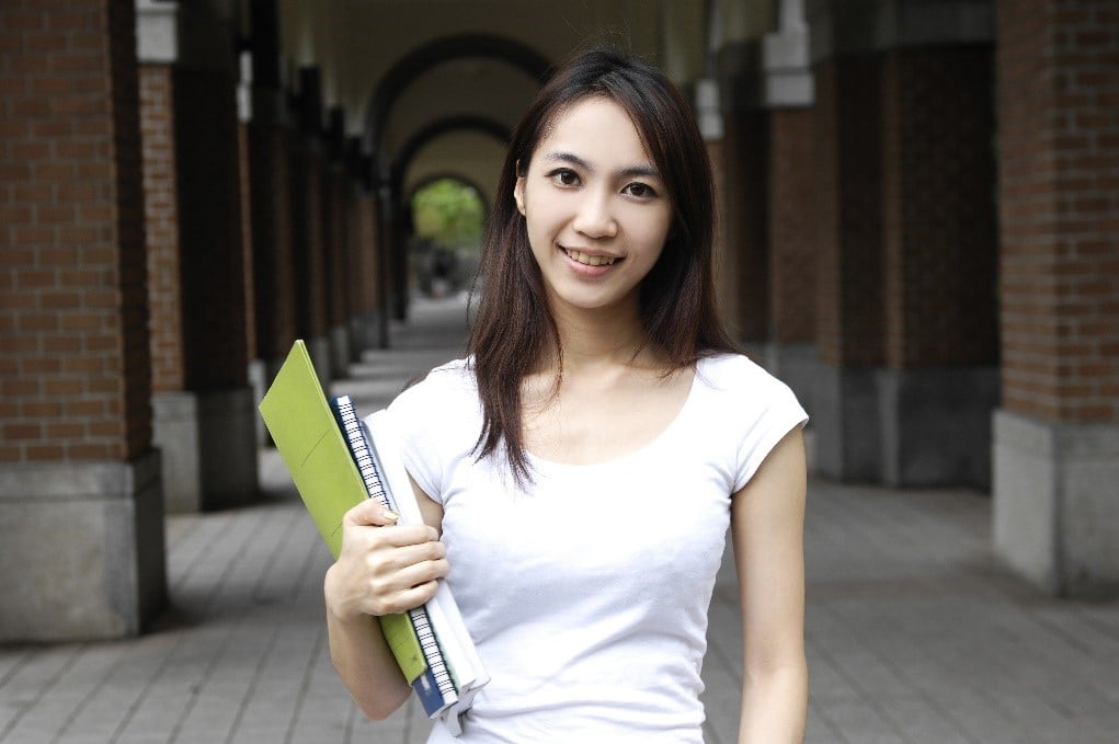 Girl Holding Books Outside Of Building