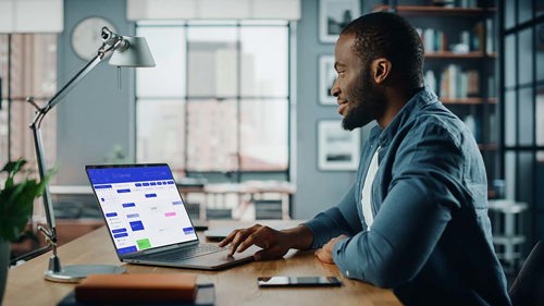 Male using laptop at home desk